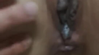 一个穿着比基尼的亚洲女孩在沙发上接吻时摩擦着乳房